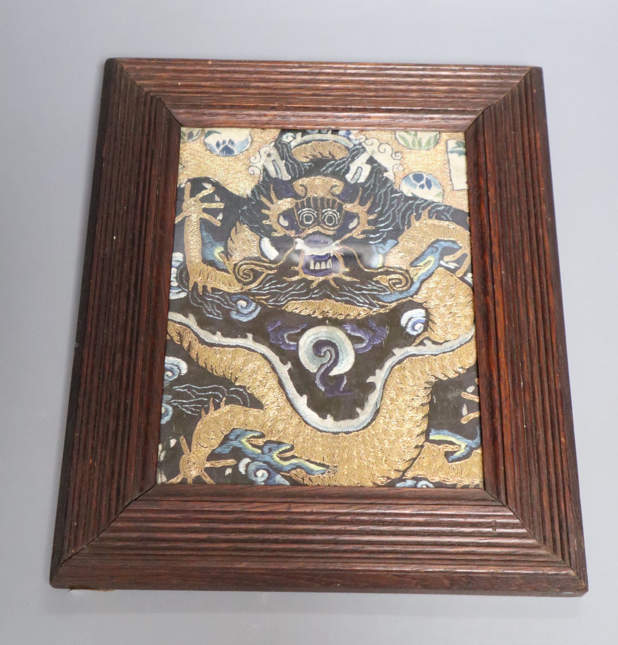 A Chinese embroidered silk and gilt wrapped thread dragon panel fragment, Qing